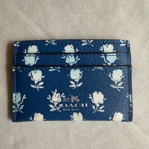 Coach Card Case with floral print on a blue background